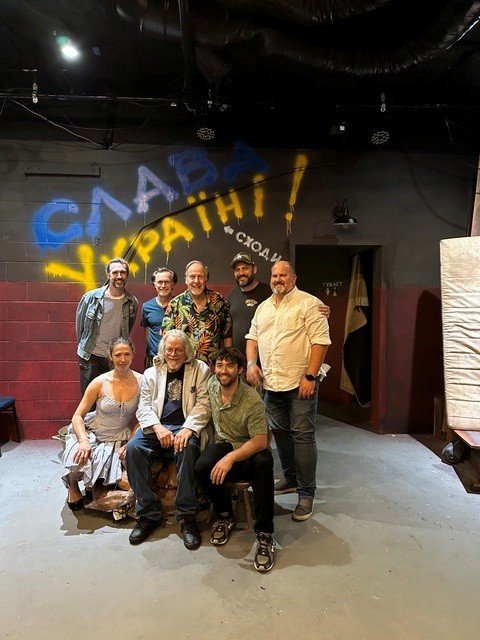 The cast and creative team of SLAVA UKRAINI! on the Azovstal set, in front of the &lsquo;Slava Ukraini!&rsquo; graffiti